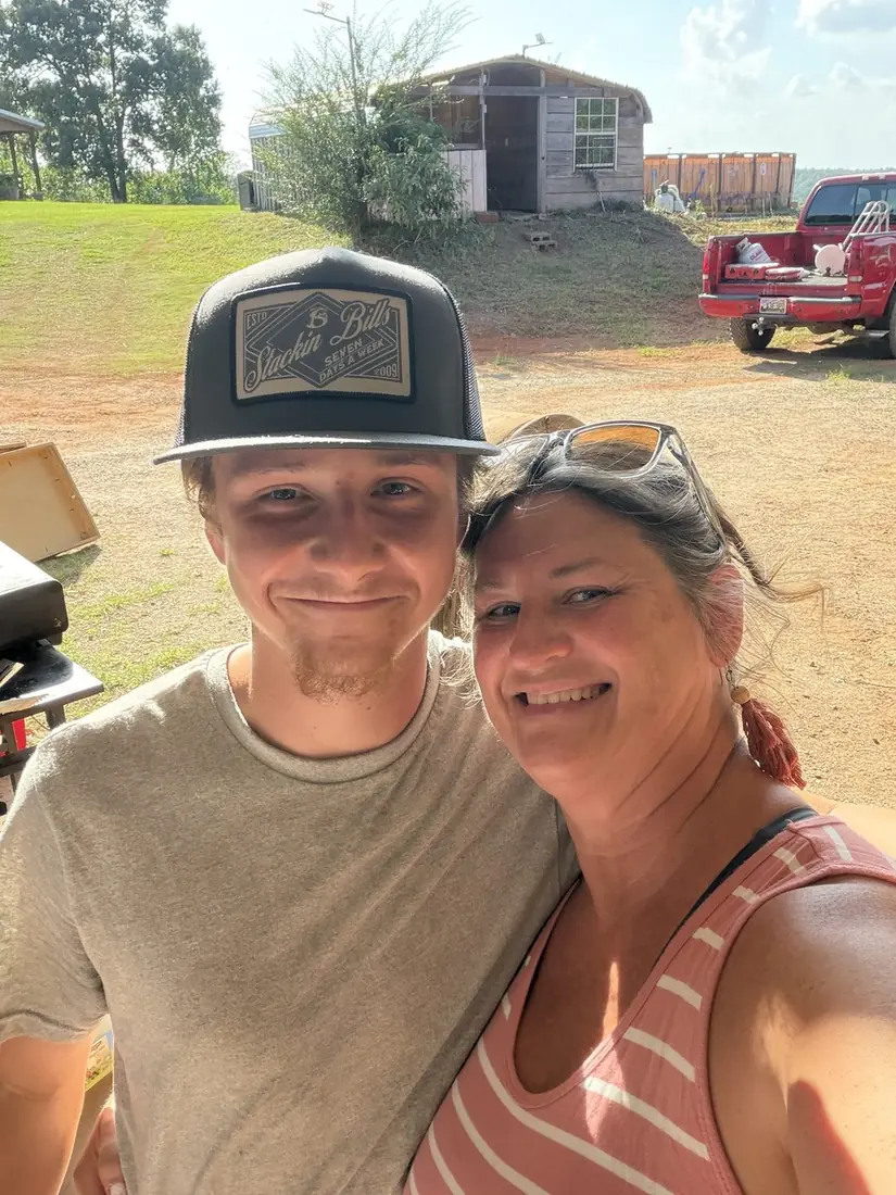 A young man and his aunt smiling together at the cookout